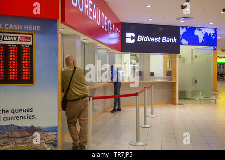 Bureau de change foreign exchange and Bidvest Bank kiosks with tourists or people at the counters in Cape Town International Airport terminal building