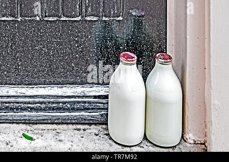 Milkbottles on the doorsteps in front of the house; Milchflaschen vor einer englischen haustür Stock Photo
