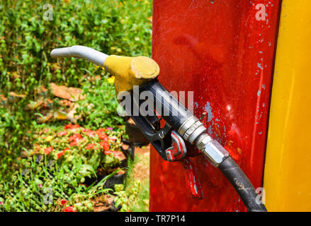 Old pump filling gun fuel nozzle to refuel in gas station Stock Photo
