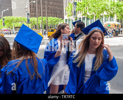 Very recent graduates from the Fashion Institute of Technology with their friends and families outside of Radio City Music Hall in New York on Wednesday, May 22, 2019 after the college's commencement exercises.  (© Richard B. Levine) Stock Photo