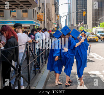 Very recent graduates from the Fashion Institute of Technology with their friends and families outside of Radio City Music Hall in New York on Wednesday, May 22, 2019 after the college's commencement exercises.  (© Richard B. Levine) Stock Photo