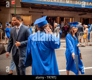 Very recent graduates from the Fashion Institute of Technology with their friends and families outside of Radio City Music Hall in New York on Wednesday, May 22, 2019 after the college's commencement exercises.  (© Richard B. Levine) Stock Photo