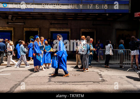 Very recent graduates from the Fashion Institute of Technology with their friends and families outside of Radio City Music Hall in New York on Wednesday, May 22, 2019 after the college's commencement exercises.  (© Richard B. Levine) Stock Photo