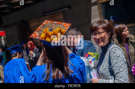 Very recent graduates from the Fashion Institute of Technology with their friends and families outside of Radio City Music Hall in New York on Wednesday, May 22, 2019 after the college's commencement exercises.  (© Richard B. Levine) Stock Photo