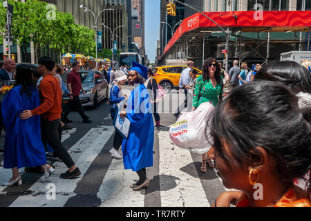 Very recent graduates from the Fashion Institute of Technology with their friends and families outside of Radio City Music Hall in New York on Wednesday, May 22, 2019 after the college's commencement exercises.  (© Richard B. Levine) Stock Photo