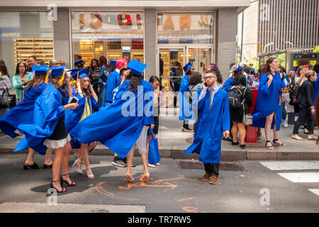 Very recent graduates from the Fashion Institute of Technology with their friends and families outside of Radio City Music Hall in New York on Wednesday, May 22, 2019 after the college's commencement exercises.  (© Richard B. Levine) Stock Photo