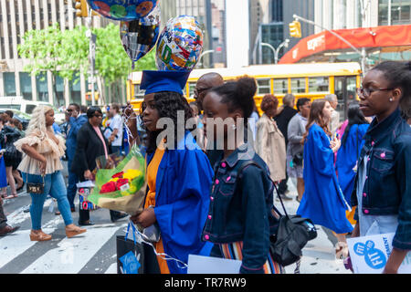 Very recent graduates from the Fashion Institute of Technology with their friends and families outside of Radio City Music Hall in New York on Wednesday, May 22, 2019 after the college's commencement exercises.  (© Richard B. Levine) Stock Photo