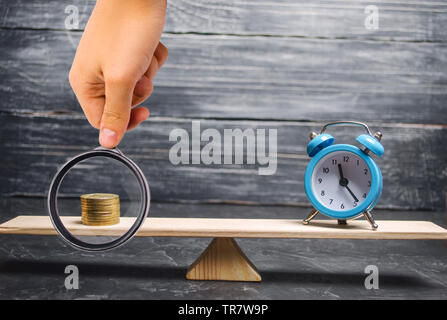 Alarm clock and money on the scales. The concept of Time is money. Business financial ideas. Saving. Financial investments, revenue increase, budget m Stock Photo