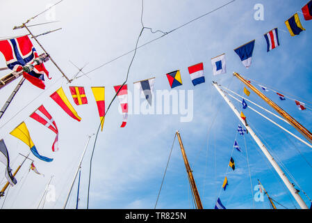 Signal flags and a norwegian flag hanging from the masts of a ship. Stock Photo