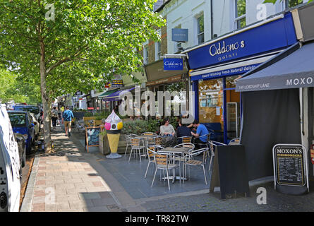 Customers sit outside Oddono's Gellati ice cream shop on Lordship Lane, East Dulwich, London UK. Sunny, summer day in south London. Stock Photo