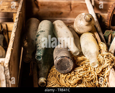 Vintage and dusty flasks stored in wooden crates. Stock Photo