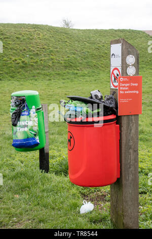 Overflowing litter bin and dog waste bin in the countryside, England UK Stock Photo