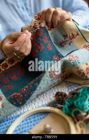 Close Up Of Senior Woman Embroidering Cushion Cover At Home Stock Photo