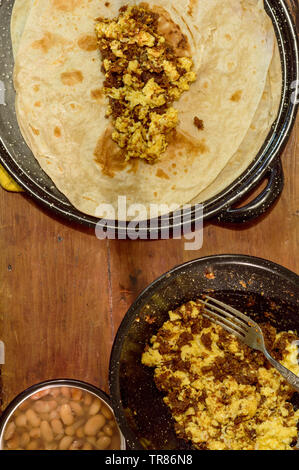 Mexican breakfast, making burritos with machaca from Sonora with eggs, beans and flour tortillas. For restaurant, food blog, etc. Mexican food. Copy s Stock Photo