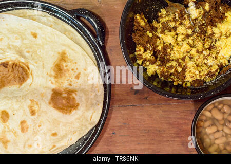 Mexican breakfast, machaca from Sonora with eggs, beans and flour tortillas. For restaurant, food blog, Mexican food. Copy space. Stock Photo