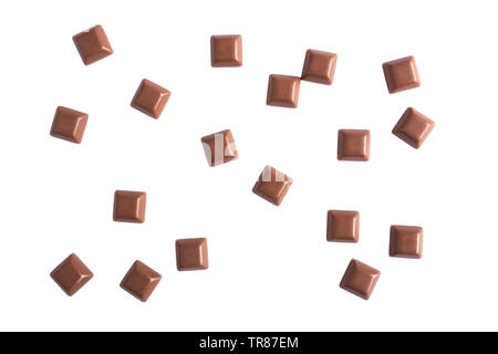 Scattered milk chocolate dice top view from above - Randomly close up pieces of chocolate bar isolated on white background flat lay viewed from above Stock Photo