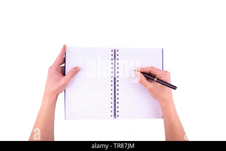 Womans hands holding pen writing on empty blank spiral notepad top view from above isolated on white background clipping - Closeup of a female hand wr Stock Photo