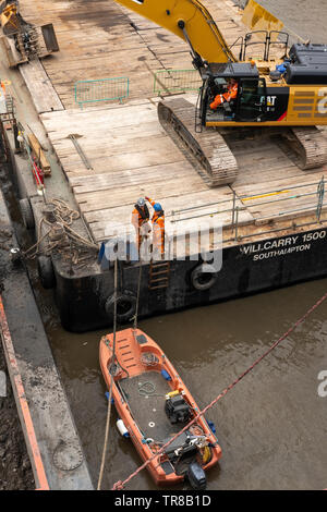 Construction workers carry work on river Thames at  Victoria Embankment, London, March 2019 Stock Photo