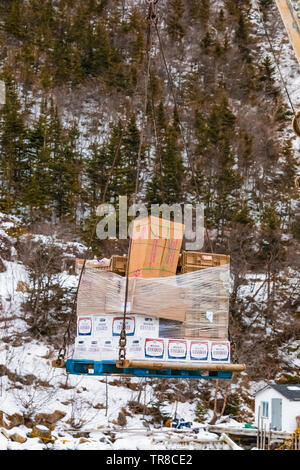 Unloading and transporting cargo, including lots of Molson, at the outport of Grey River, viewed from the ferry Marine Voyager, Newfoundland, Canada [ Stock Photo