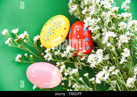 Easter eggs decoration white cutter flower on green background - top view Stock Photo