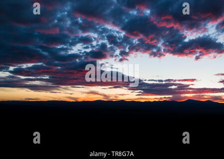 Purple and pink outlines beautiful clouds at sunset over a mountain range silhouetted against the sky - Jemez Mountains near Santa Fe, New Mexico Stock Photo