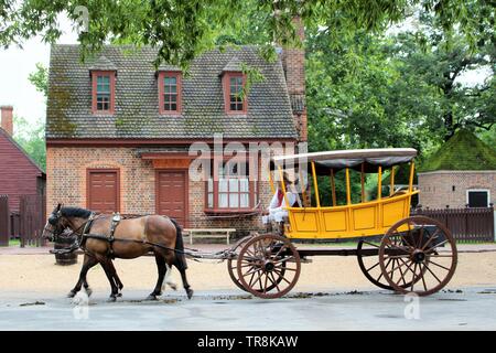 Horse and yellow carriage on Duke of Gloucester street at Colonial Williamsburg Stock Photo