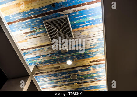 Air conditioner mask, lighting and modern equipment On the ceiling that decorated with old wooden panels and peeling paint Stock Photo