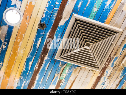 Air conditioner mask, lighting and modern equipment On the ceiling that decorated with old wooden panels and peeling paint Stock Photo