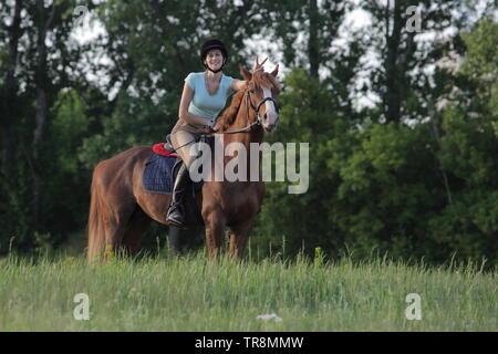 Young female equestrian riding on saddle arabian horse Stock Photo