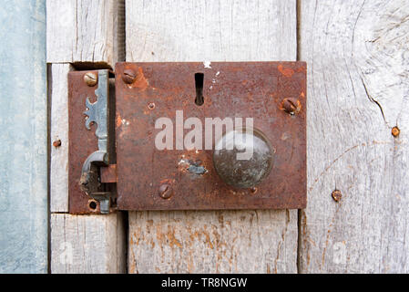 An old rusted door handle and lock on the outside of a country farm shed (barn) in New South Wales, Australia Stock Photo