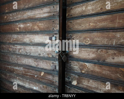 Wooden weathered antique gates closed with padlock. Stock Photo