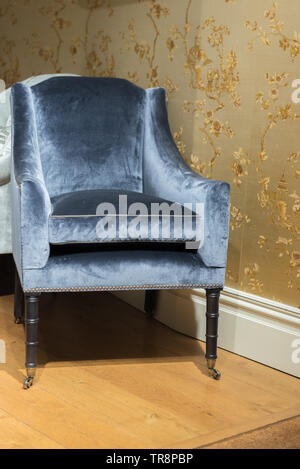 Expensive Vinrage Armchair in Gold Wallpapered Room Stock Photo