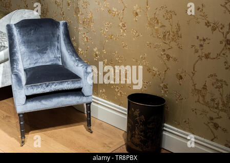 Expensive Vinrage Armchair in Gold Wallpapered Room Stock Photo