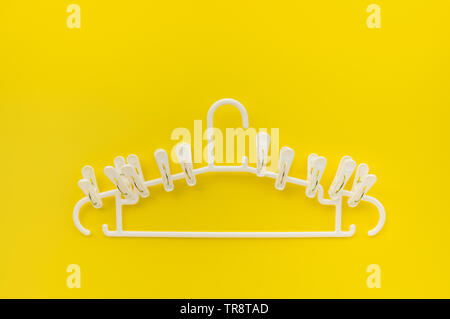 clothespins with hangers on yellow color background,copy space Stock Photo