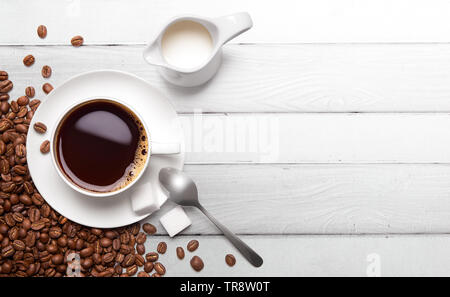 Roasted coffee beans and cup of black coffee over white painted wood background Stock Photo