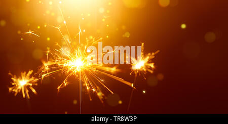 Glittering burning sparkler against golden bokeh background Stock Photo