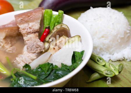 Philippine traditional dish: Sinagang pork soup with vegetables and rice Stock Photo