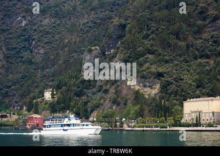Riva di Garda, Italy - March 2018: Boat on lake green mountains background Stock Photo