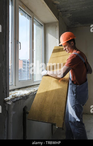 Worker is installing a window sill on a polyurethane foam. Stock Photo