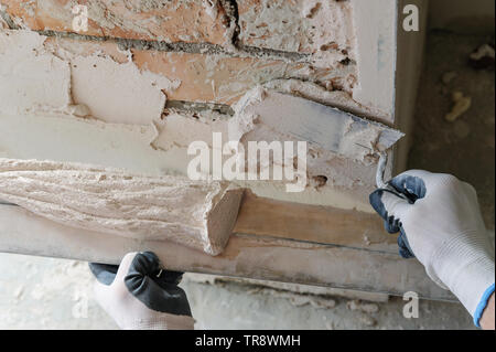 Worker is putting a gypsum plaster on a brick wall. Stock Photo
