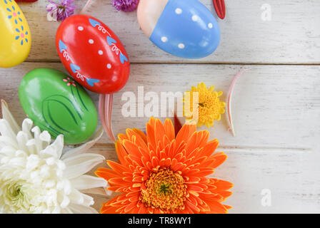 Easter eggs decoration coloerful flower with gerbera and chrysanthemum flowers on white wooden background Stock Photo