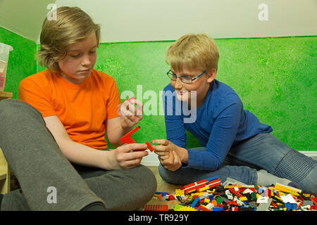 two boys playing together with Lego, Germany Stock Photo