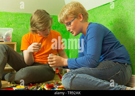 two boys playing together with Lego, Germany Stock Photo