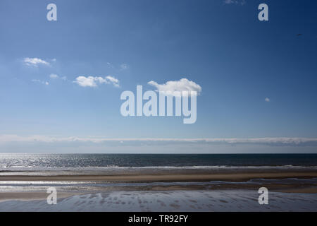 Low tide on empty Cleveleys beach with blue sky and cumulus clouds in lancashire uk Stock Photo