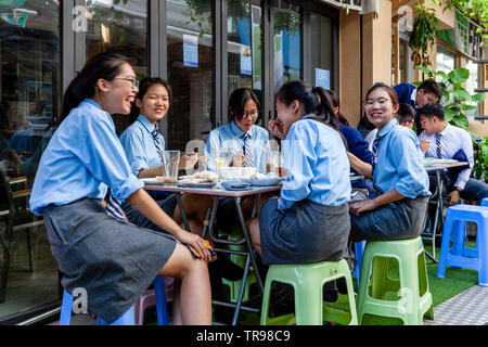 Female School Students Eating Lunch At A Cafe, Stanley, Hong Kong, China Stock Photo