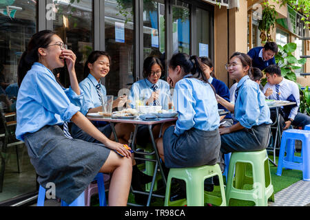 Female School Students Eating Lunch At A Cafe, Stanley, Hong Kong, China Stock Photo
