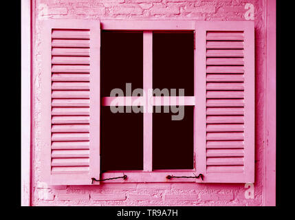 Pink colored window shutters on the pink brick wall Stock Photo