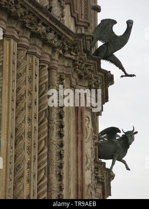 Close-up view of the intricate columns and two sculptures on the front façade of the Orvieto Cathedral Stock Photo