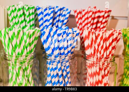 Assorted color striped straws, single use plastic alternative, in jars displayed at booth at National Restaurant Association Show held in Chicago, USA Stock Photo