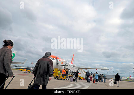 Passengers with carry on luggage at Lisbon airport walking across the tarmac to board an Easyjet plane to fly to London England UK  2019 KATHY DEWITT Stock Photo